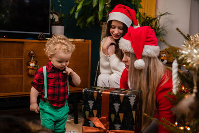 Rear view of woman holding christmas tree