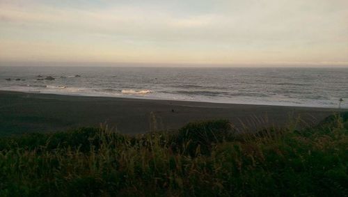 Scenic view of sea against cloudy sky