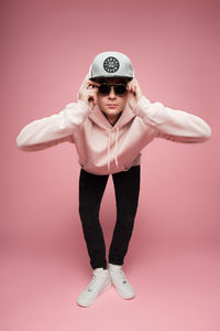 Man in sunglasses against pink background