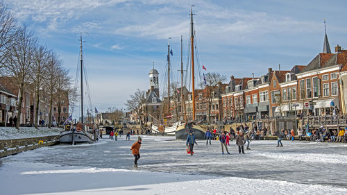 Skaters on the frozen river ee in historical dokkum in the netherlands in winter