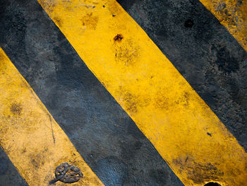 High angle view of yellow arrow symbol on road