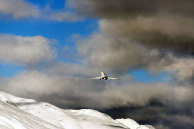 Airplane flying in cloudy sky