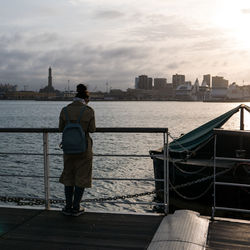 Rear view of man standing on railing