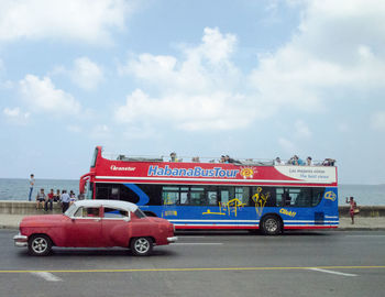 Cars on city street against sky