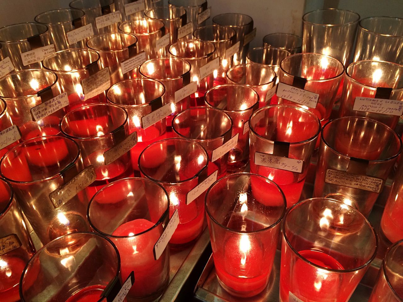 indoors, red, large group of objects, in a row, abundance, arrangement, order, still life, variation, illuminated, retail, repetition, hanging, choice, close-up, side by side, for sale, collection, shelf, lighting equipment