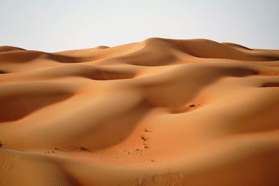 Sand dune in desert against clear sky