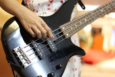 Midsection of woman playing electric guitar