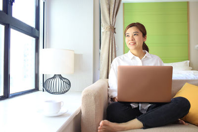 Young woman using mobile phone at home