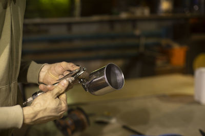 Midsection of man repairing drum