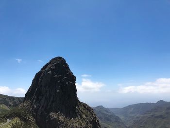 Scenic view of mountains against blue sky