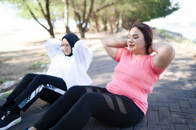 Side view of young woman exercising in park