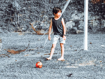 Full length of boy playing soccer at park