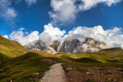 Road by mountains against sky