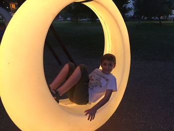 Full length portrait of boy on slide at playground