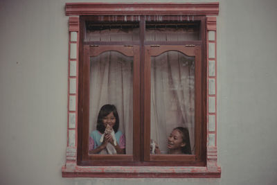 Portrait of smiling woman in window