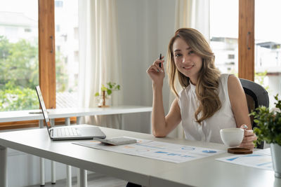 Young woman using laptop at table