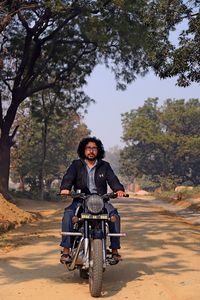 Portrait of man riding motorcycle on road