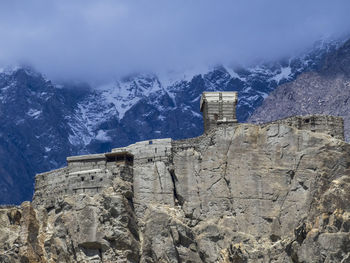 Built structure on snowcapped mountain against sky