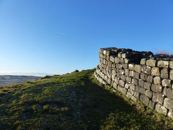 Stone wall against clear blue sky