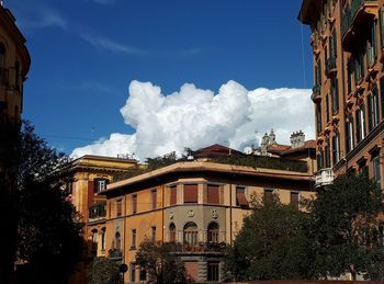 Low angle view of buildings against cloudy sky