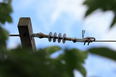 Low angle view of barbed wire fence against sky