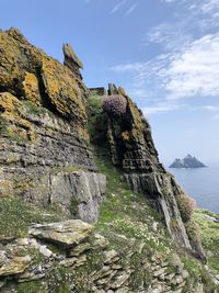 Rock formation by mountain against sky