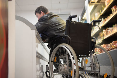 A disabled person in a wheelchair buys groceries