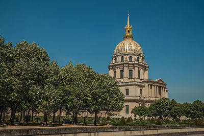 View of trees and building against sky