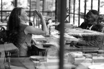 Man high fiving woman at restaurant