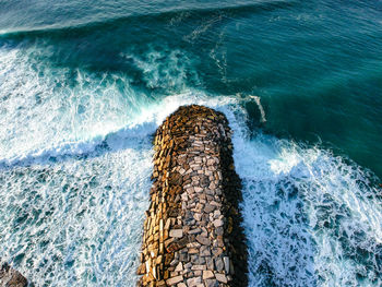 Aerial view from a stone jetty. stone wave breaker blocks to protect the coast from erosion