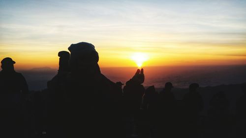 Silhouette people against sky during sunset