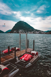 Boats moored by pier at lake