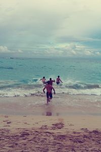 Men on beach against sky