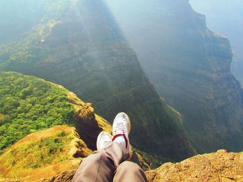 Low section of man relaxing on mountain