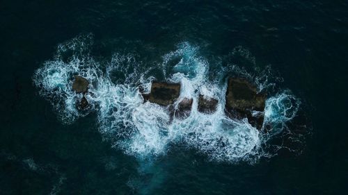 High angle view of water splashing on rocks