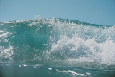 Water splashing in sea against clear sky