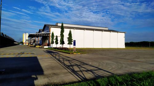 Road by building against blue sky