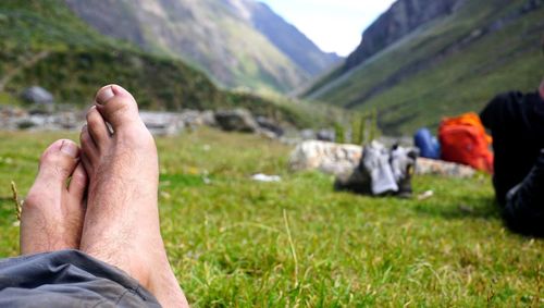 Midsection of person relaxing on field