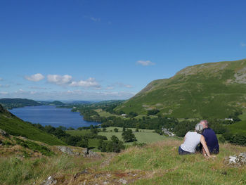 Rear view of  couple on mountain against sky