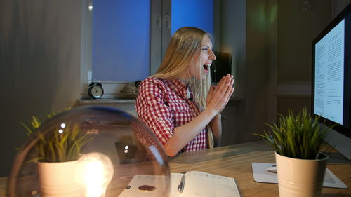 Woman sitting on table at home