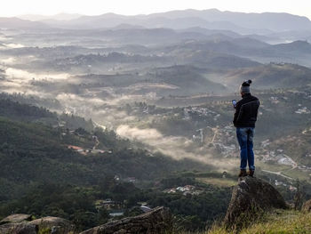 Rear view of man standing on mountain