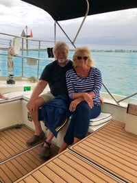 Full length of friends sitting on boat in water