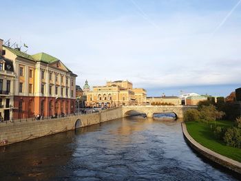 Arch bridge over river against buildings in city