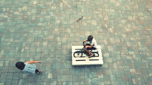 High angle view of man sitting on tiled floor