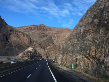 Road by mountain against sky