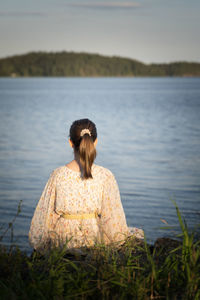 Rear view of woman looking at sea against sky