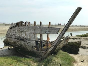 Abandoned boats on beach against sky