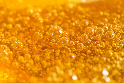 Full frame shot of wet yellow bubbles