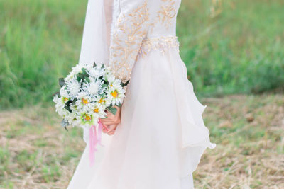 Close-up of woman holding bouquet of white flower