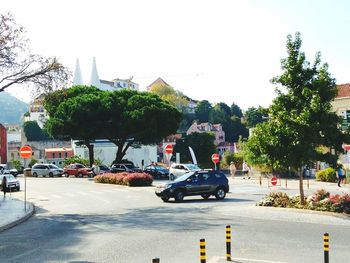 Traffic on road in city against clear sky